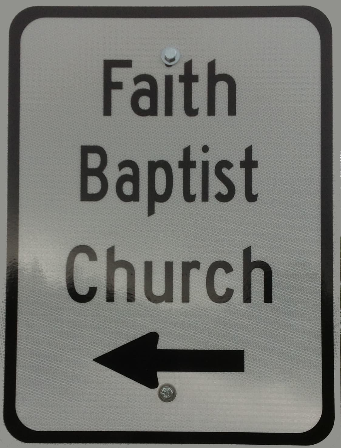 The Faith Baptist Church road sign pointing toward the church
